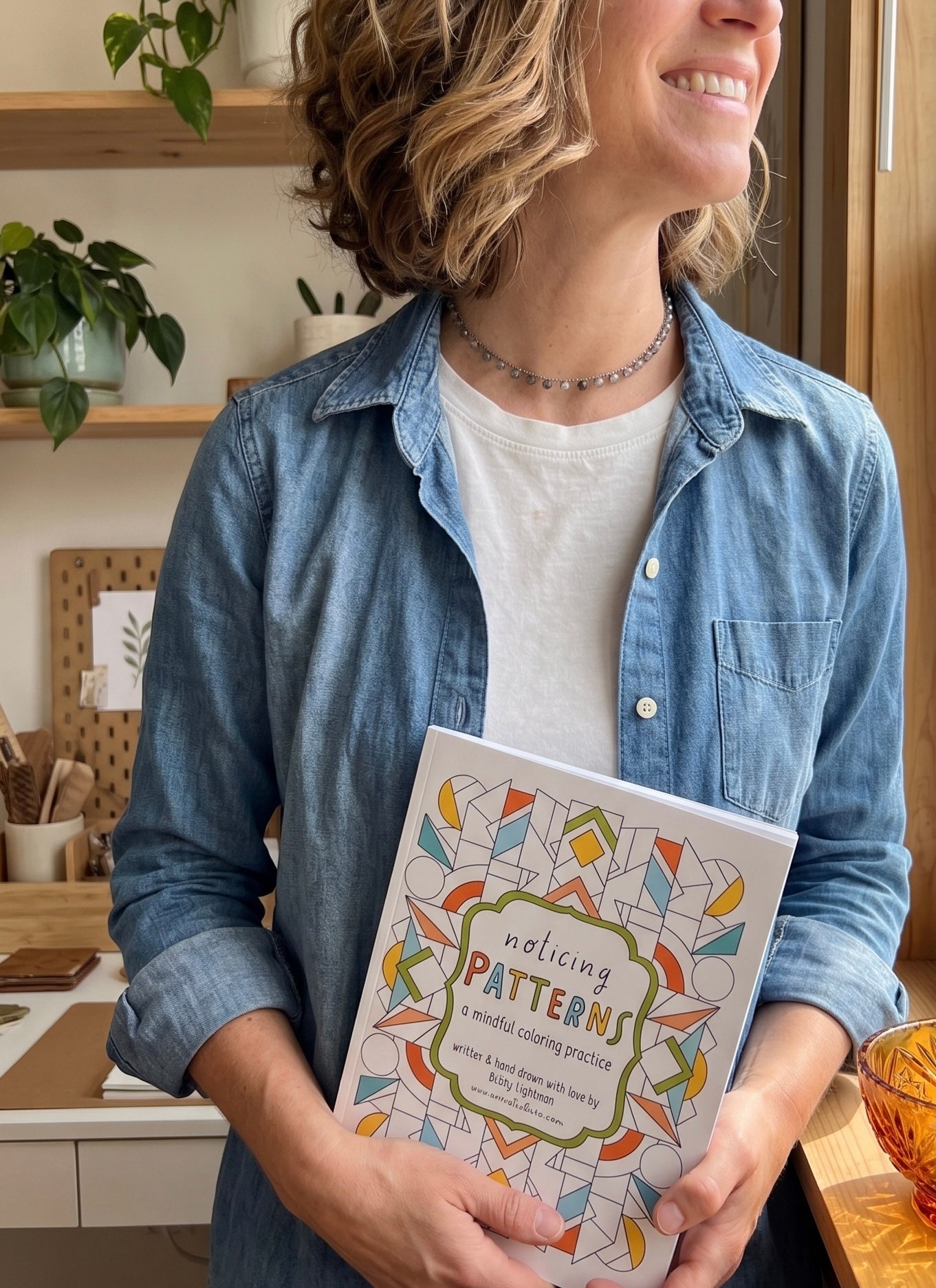 the artist holding the mindful coloring book